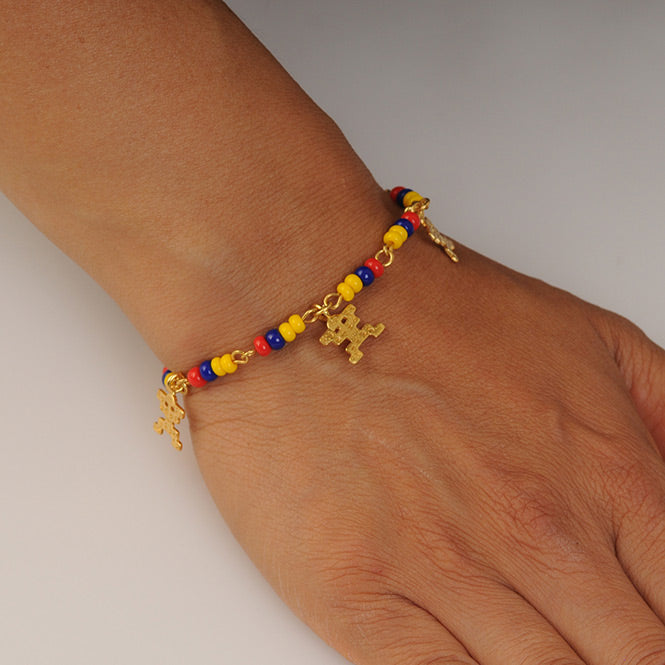 Woman wearing 24K gold-plated Colombian charm bracelet — elegant handmade fashion accessory symbolizing identity, joy, and tradition